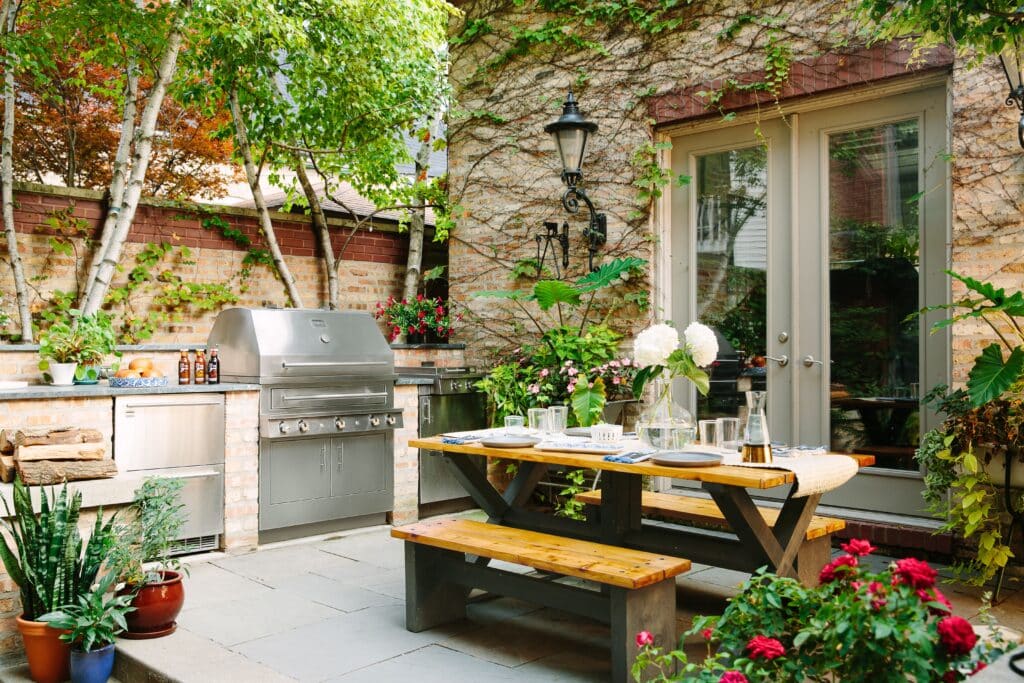 Outdoor Kitchen with countertop, small dining, culinary surrounded with plants in the backyard 