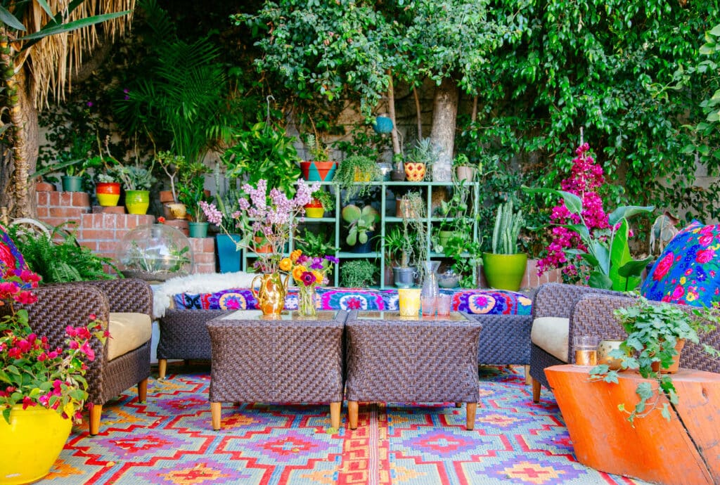 Vibrant rug with matching sofas, cushions and pots in the backyard