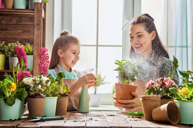 mother and daughter watering the plants in a room