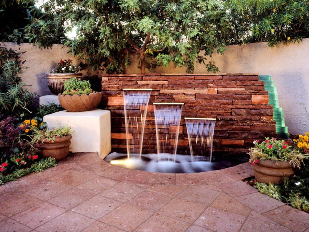 Water Feature in the backyard with colorful flowers and trees