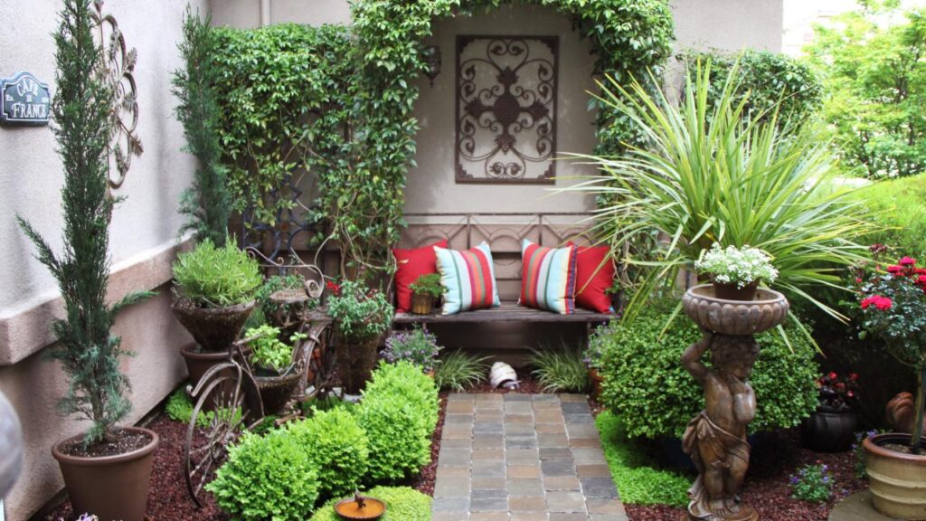 backyard of a house decorated with flowers, plants and a sofa with colorful cushions