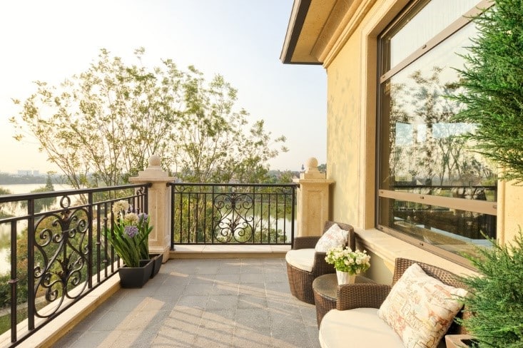 a view of a balcony having cushioned seats and planters