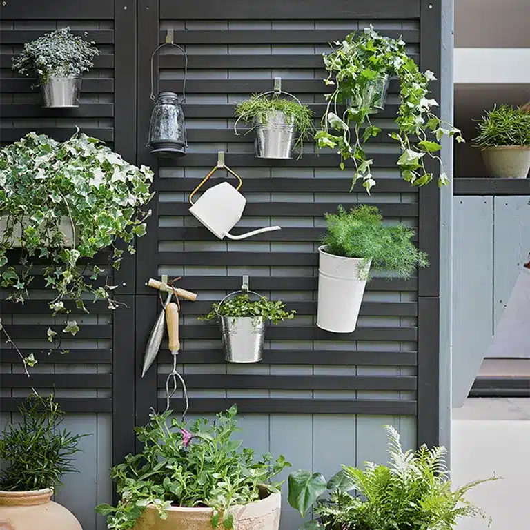 terrace garden ornamental wall having potted plants and gardening tools hanging