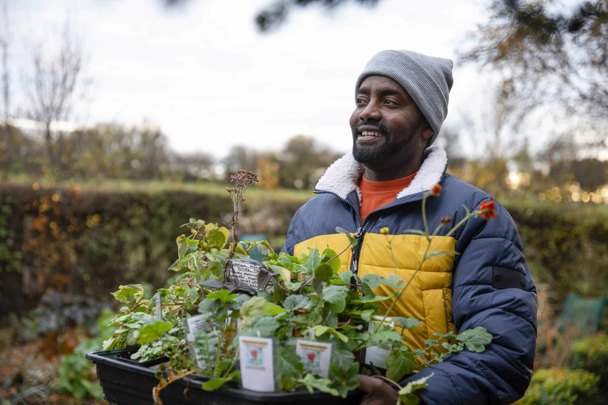 A person holding a plant pot wearing winter clothes