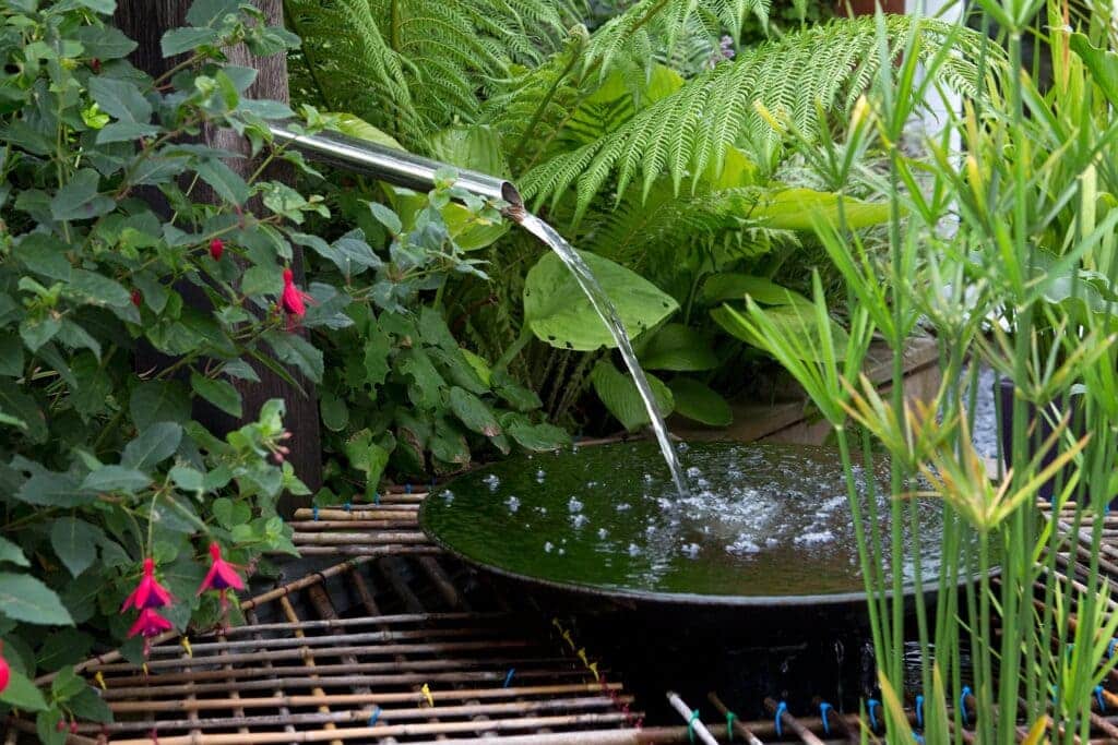 A view of a water feature pouring water inside a garden