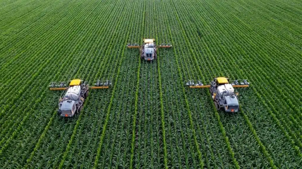 An overhead view of a farming tractors moving over a farm for agriculture