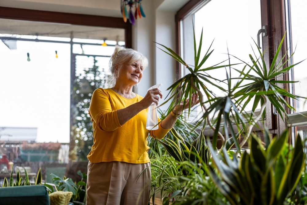 A view a woman caring for her indoor gardens